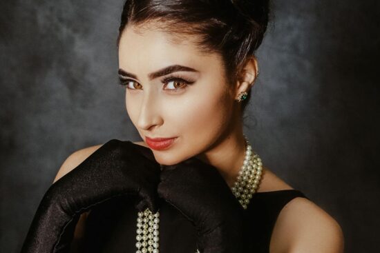 a young female looking at camera and wearing evening wear from past