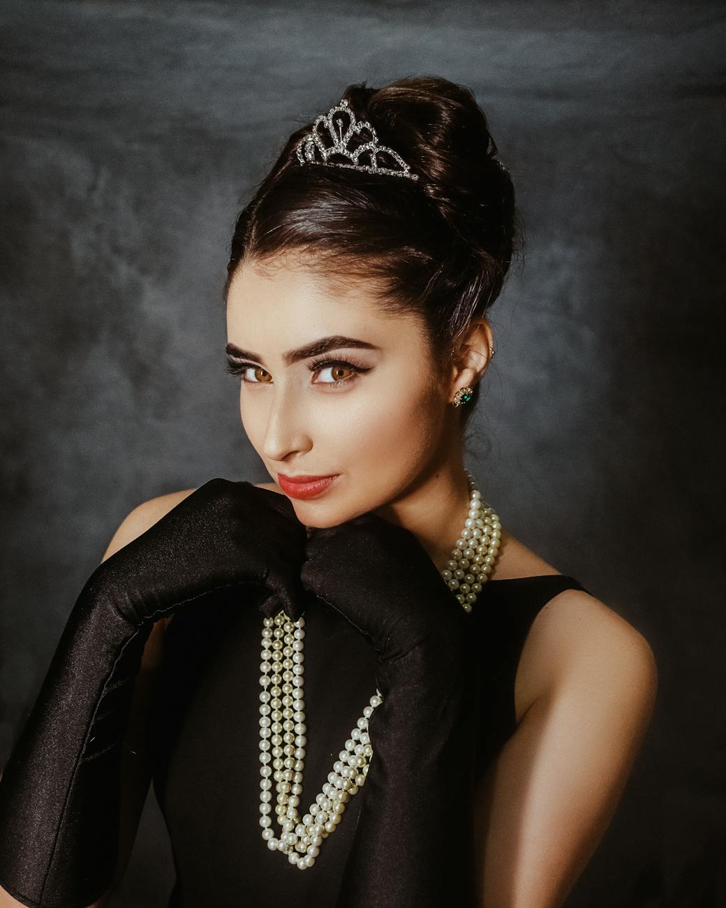a young female looking at camera and wearing evening wear from past