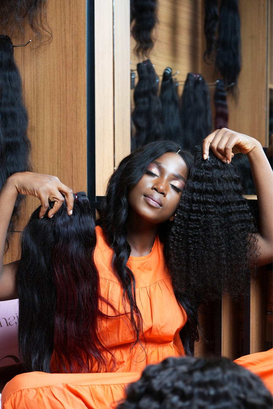 woman sitting and holding wigs