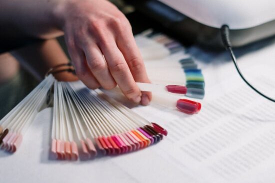 person holding artificial nail samples
