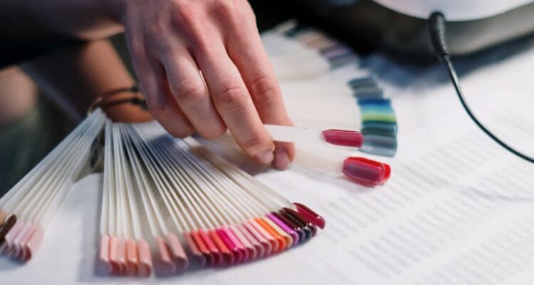 person holding artificial nail samples