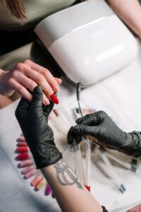 person wearing black gloves making nails