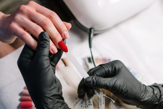 person wearing black gloves making nails