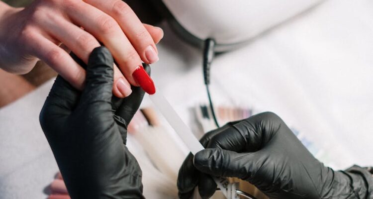 person wearing black gloves making nails