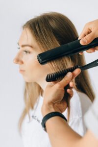a person styling a woman s hair